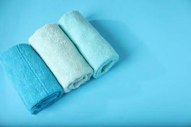 Photo of Different soft towels on light blue background, above view. Space for text