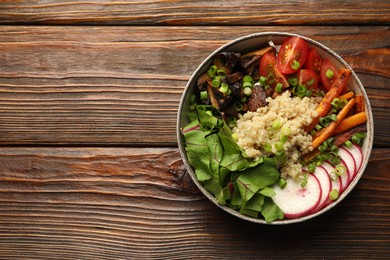 Photo of Healthy vegetarian food. Delicious Buddha bowl with quinoa, mushrooms and vegetables on wooden table, top view. Space for text