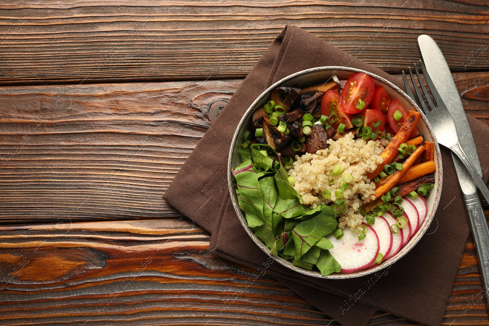 Healthy vegetarian food. Delicious Buddha bowl with quinoa, mushrooms and vegetables on wooden table, flat lay. Space for text Photo of Healthy vegetarian food. Delicious Buddha bowl with quinoa, mushrooms and vegetables on wooden table, flat lay. Space for text