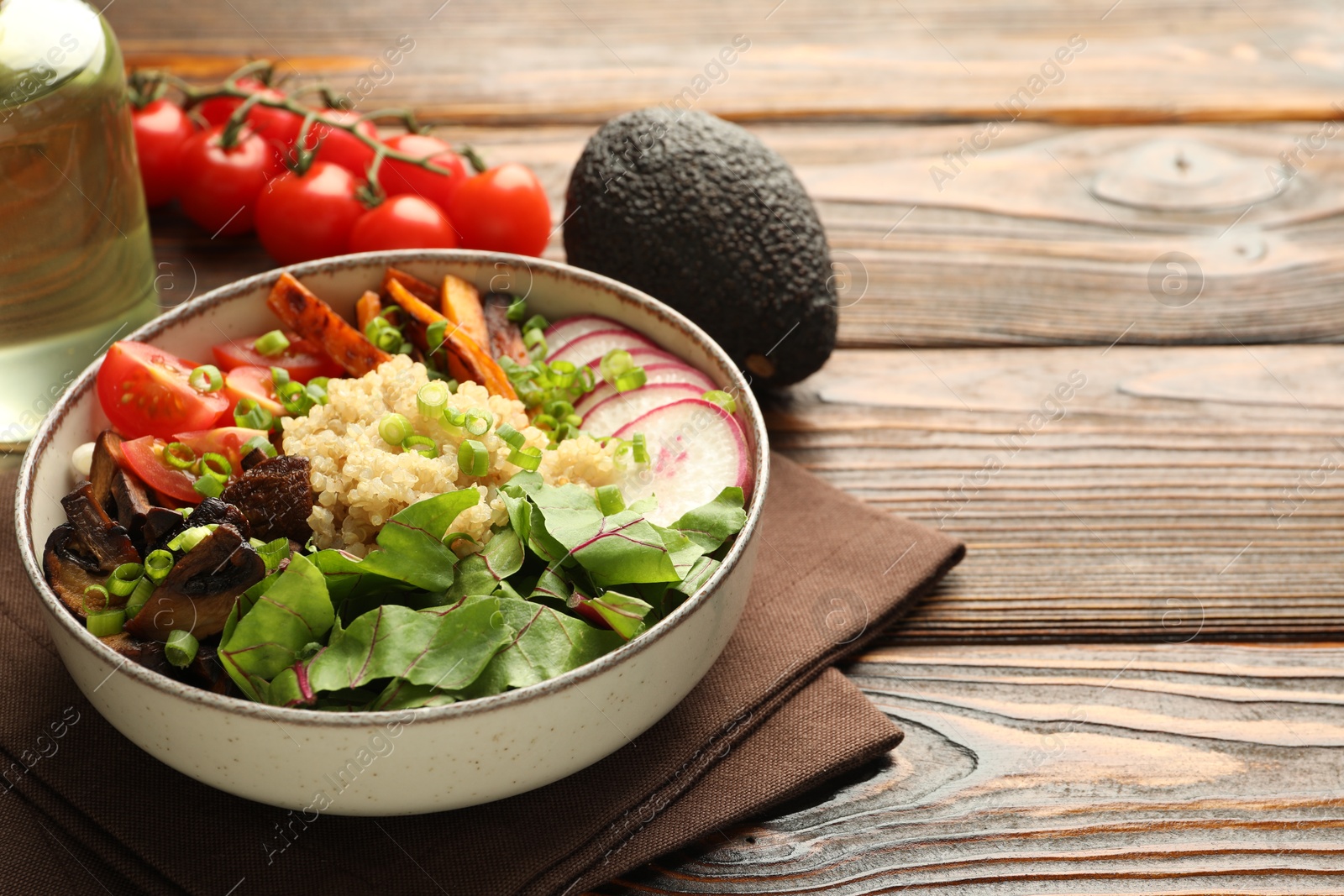 Photo of Healthy vegetarian food. Delicious Buddha bowl and ingredients on wooden table, closeup. Space for text