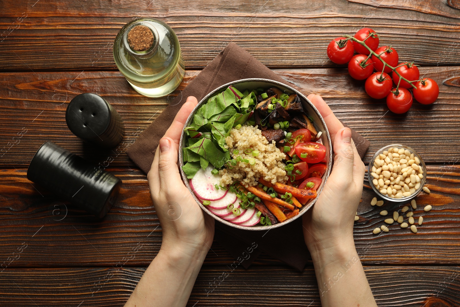 Healthy vegetarian food. Woman with delicious Buddha bowl and ingredients at wooden table, top view Photo of Healthy vegetarian food. Woman with delicious Buddha bowl and ingredients at wooden table, top view