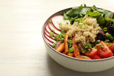 Photo of Healthy vegetarian food. Delicious Buddha bowl with quinoa, mushrooms and vegetables on light wooden table, closeup. Space for text
