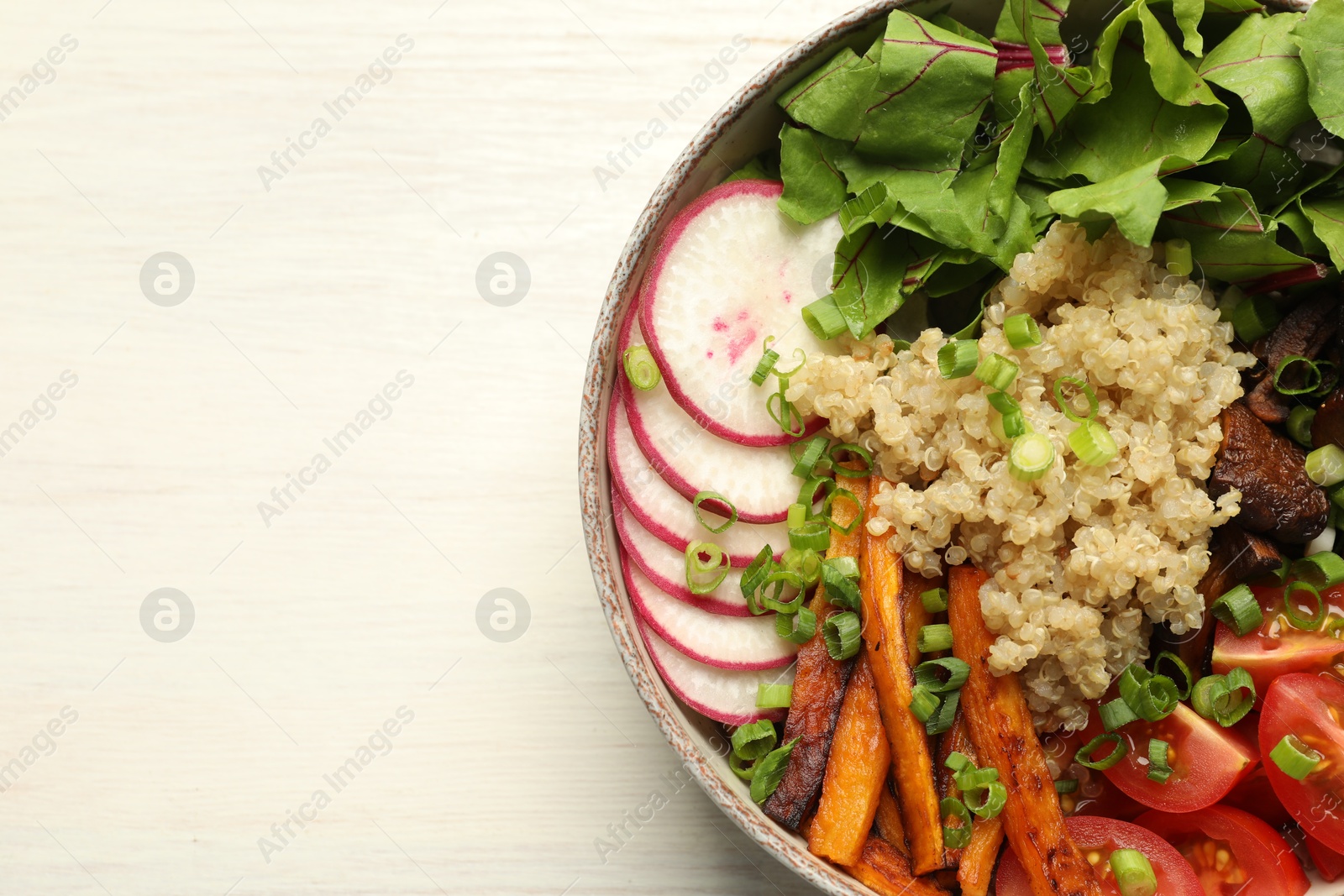 Photo of Healthy vegetarian food. Delicious Buddha bowl with quinoa, mushrooms and vegetables on light wooden table, top view. Space for text