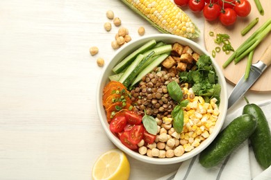 Photo of Healthy vegetarian food. Delicious Buddha bowl and ingredients on light wooden table, flat lay. Space for text