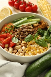Photo of Healthy vegetarian food. Delicious Buddha bowl and ingredients on table, closeup