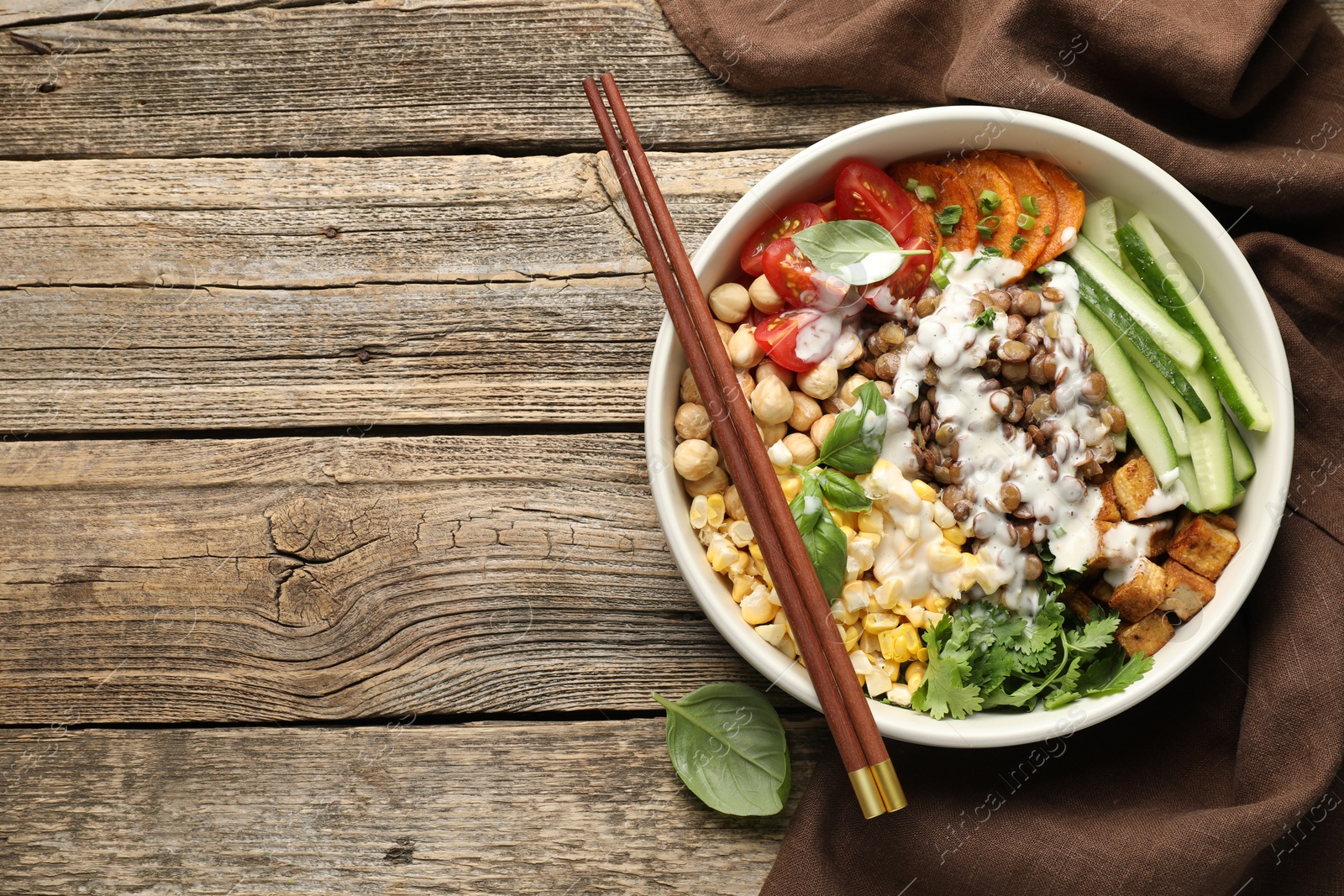 Photo of Healthy vegetarian food. Delicious Buddha bowl served on wooden table, top view. Space for text