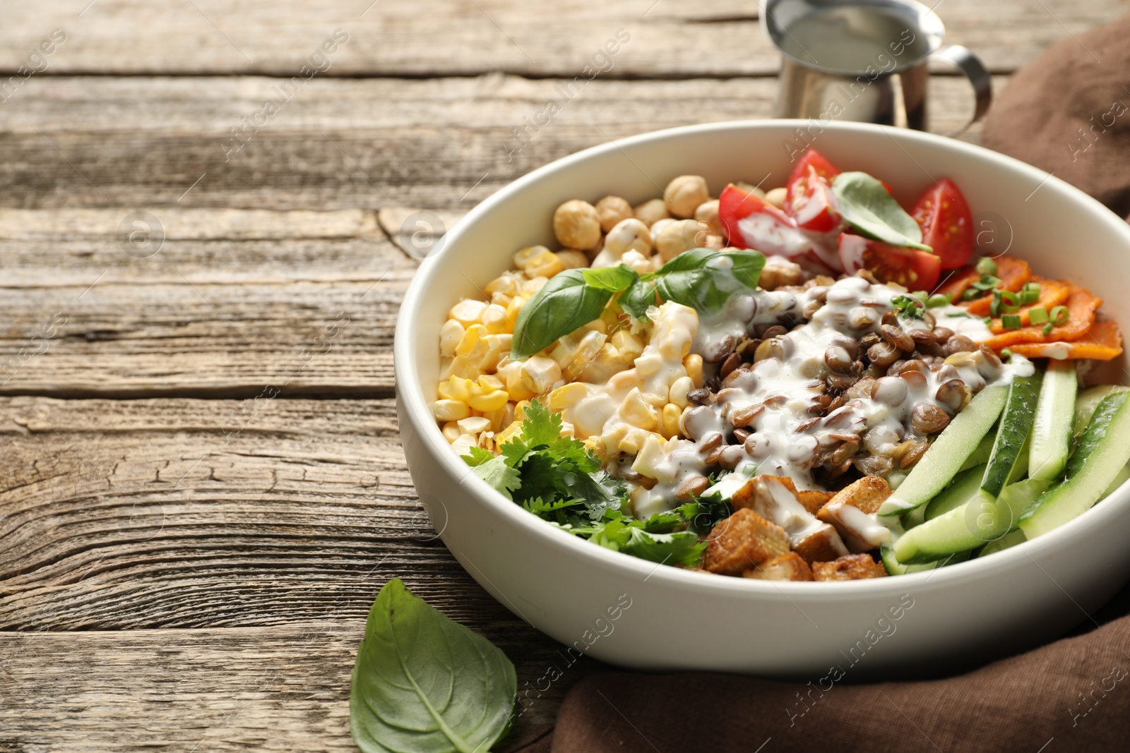Photo of Healthy vegetarian food. Delicious Buddha bowl served on wooden table, closeup. Space for text