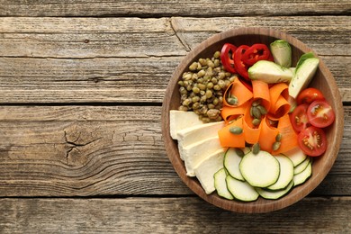 Photo of Healthy vegetarian food. Delicious Buddha bowl with lentils, tofu and vegetables on wooden table, top view. Space for text