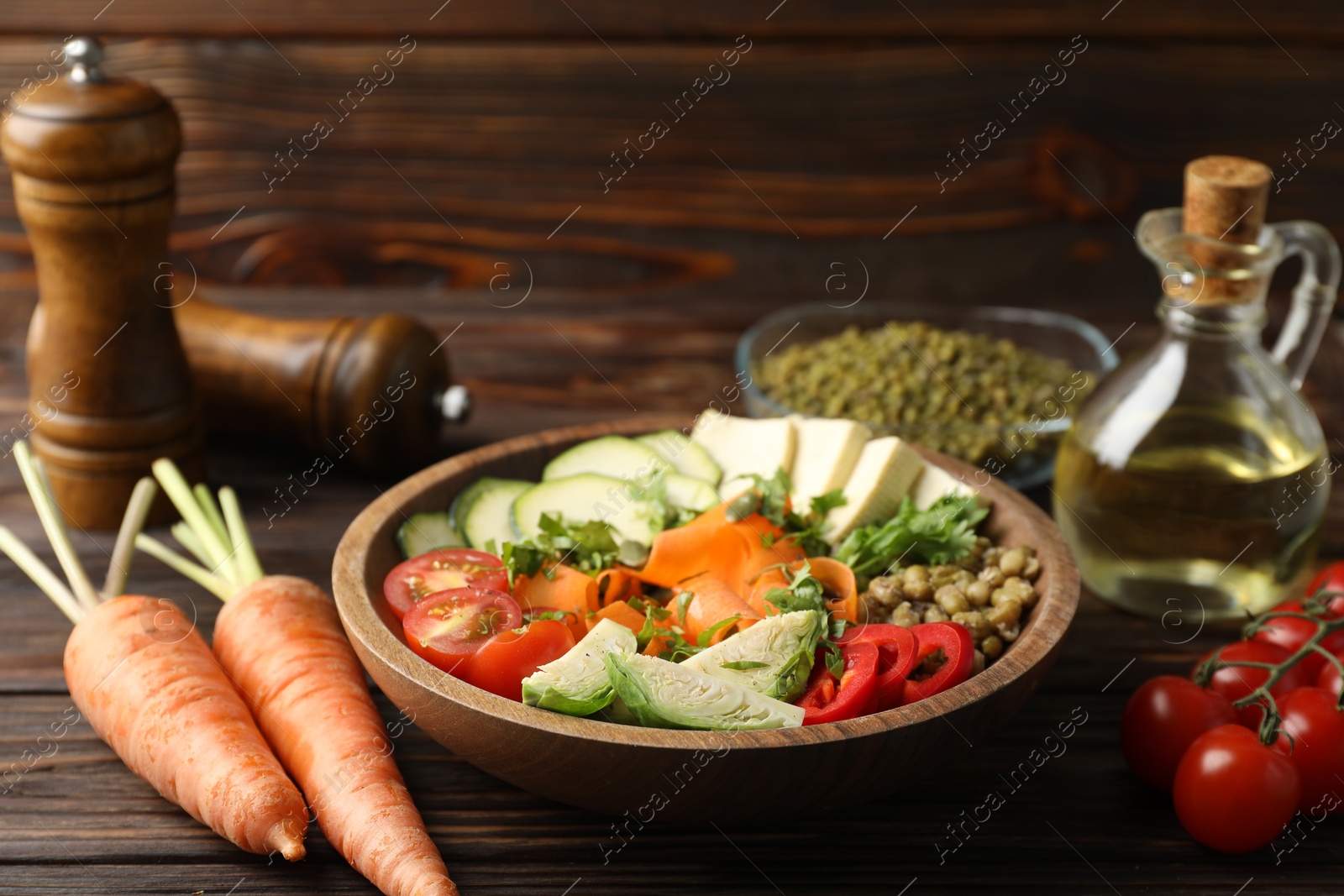 Photo of Healthy vegetarian food. Delicious Buddha bowl and ingredients on wooden table, closeup