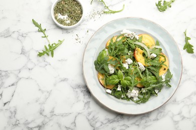 Photo of Tasty salad with arugula, cheese, peach, basil and spices on white marble table, flat lay. Space for text