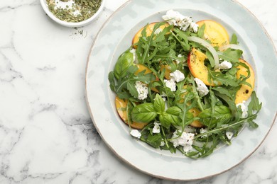 Photo of Tasty salad with arugula, cheese, peach, basil and spices on white marble table, flat lay. Space for text