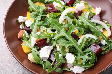 Photo of Tasty salad with arugula, cheese, peach, beetroot and nuts on grey table, closeup
