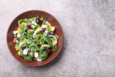 Photo of Tasty salad with arugula, cheese, peach, beetroot and nuts on grey table, top view. Space for text