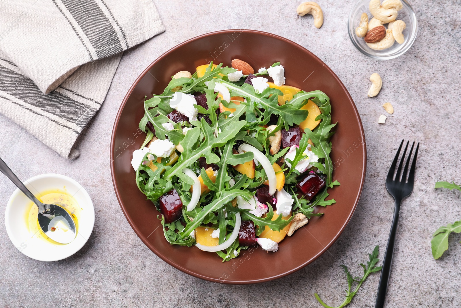 Tasty salad with arugula, cheese, peach, beetroot and nuts on grey table, flat lay Photo of Tasty salad with arugula, cheese, peach, beetroot and nuts on grey table, flat lay