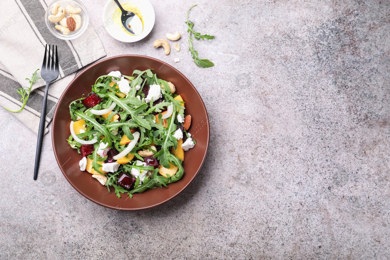 Tasty salad with arugula, cheese, peach, beetroot and nuts on grey table, flat lay. Space for text Photo of Tasty salad with arugula, cheese, peach, beetroot and nuts on grey table, flat lay. Space for text