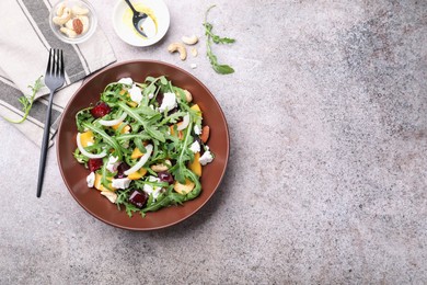 Photo of Tasty salad with arugula, cheese, peach, beetroot and nuts on grey table, flat lay. Space for text