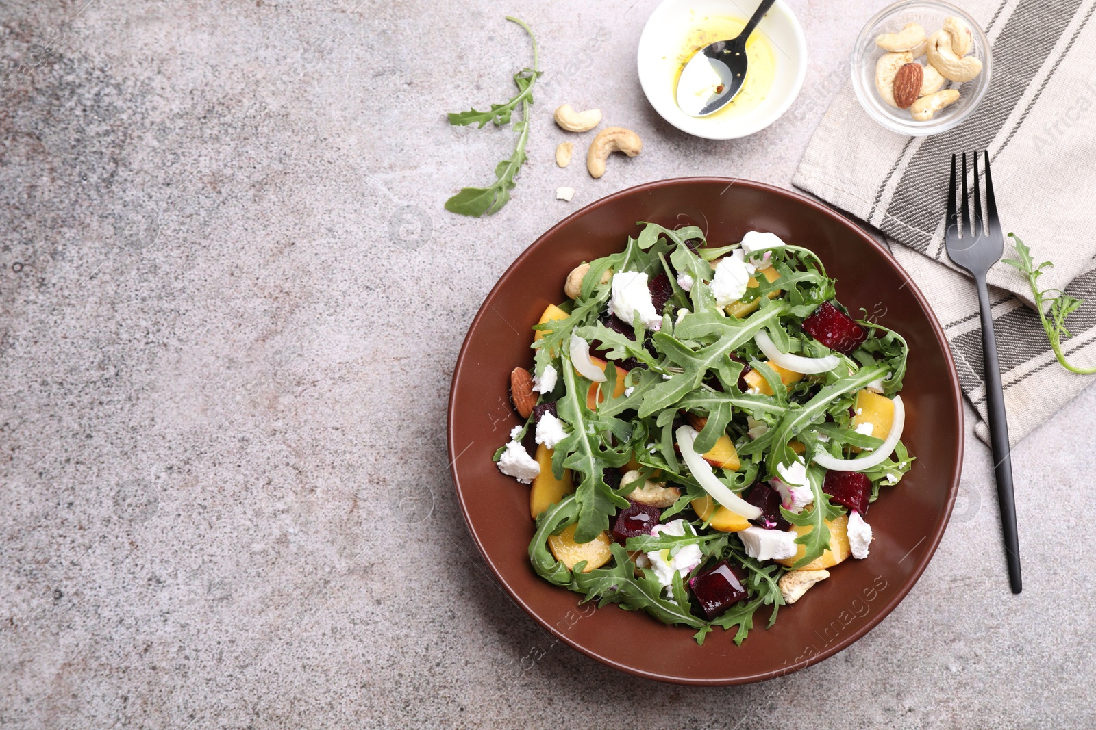Tasty salad with arugula, cheese, peach, beetroot and nuts on grey table, flat lay. Space for text Photo of Tasty salad with arugula, cheese, peach, beetroot and nuts on grey table, flat lay. Space for text