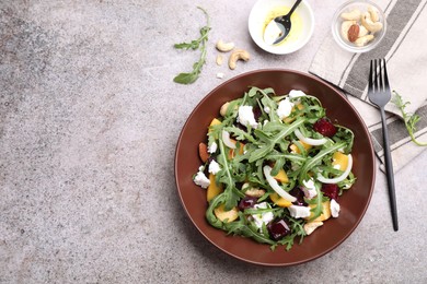 Photo of Tasty salad with arugula, cheese, peach, beetroot and nuts on grey table, flat lay. Space for text