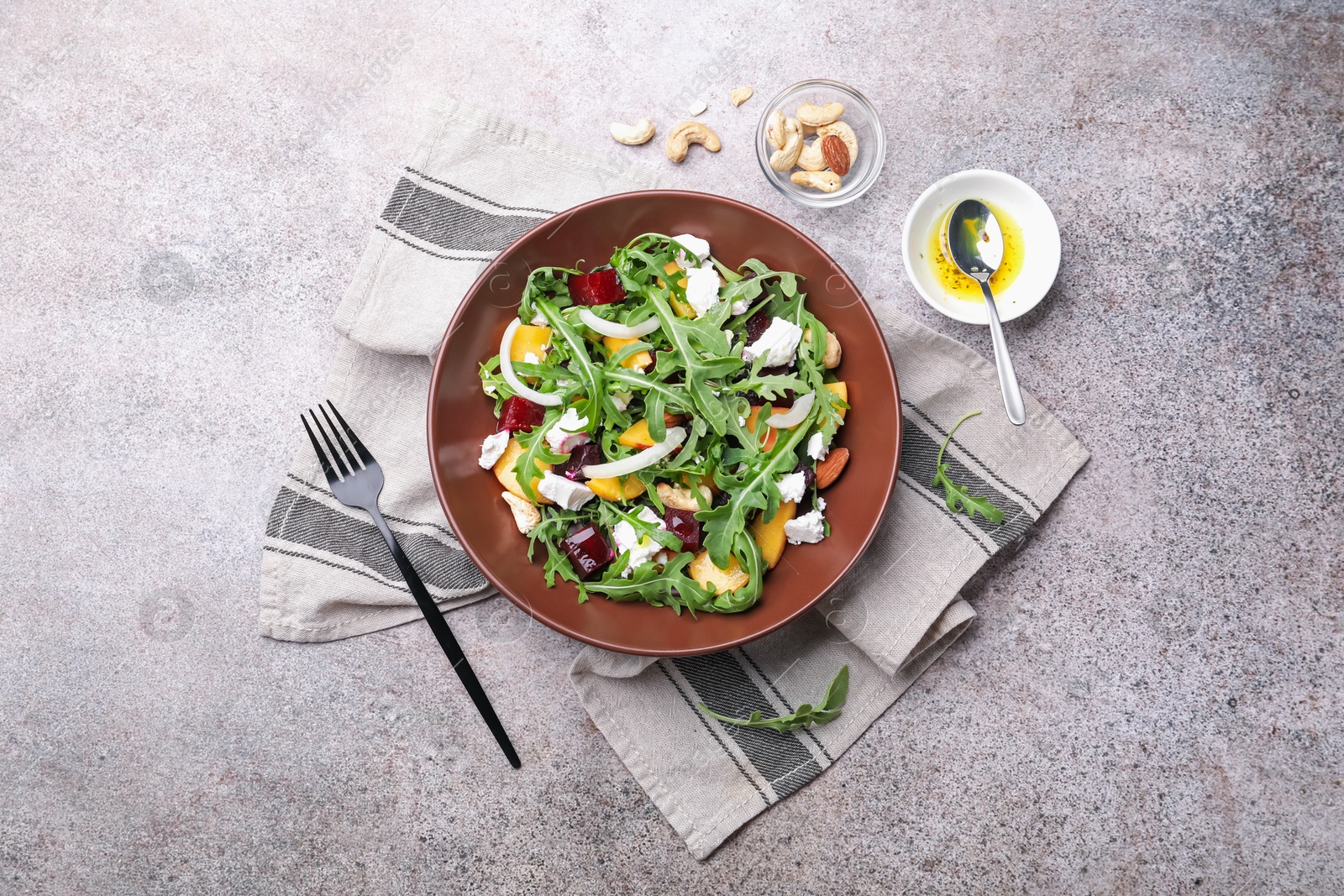 Tasty salad with arugula, cheese, peach, beetroot and nuts on grey table, flat lay Photo of Tasty salad with arugula, cheese, peach, beetroot and nuts on grey table, flat lay