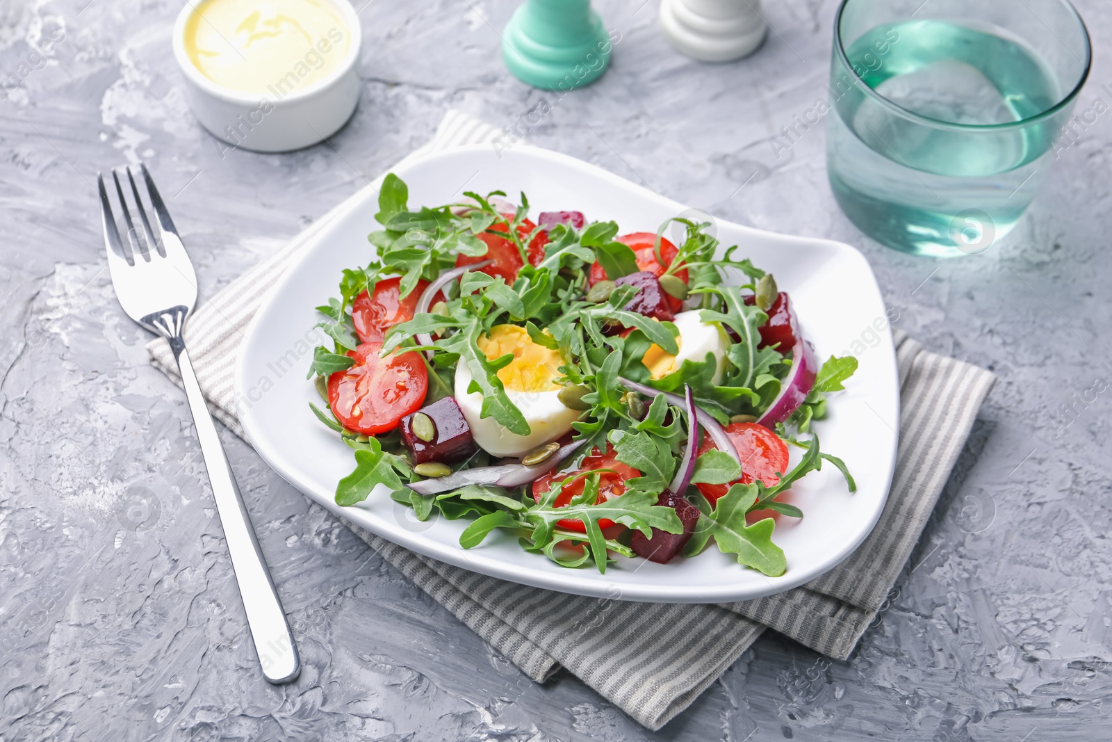 Tasty salad with arugula, vegetables and egg served on grey table, closeup Photo of Tasty salad with arugula, vegetables and egg served on grey table, closeup