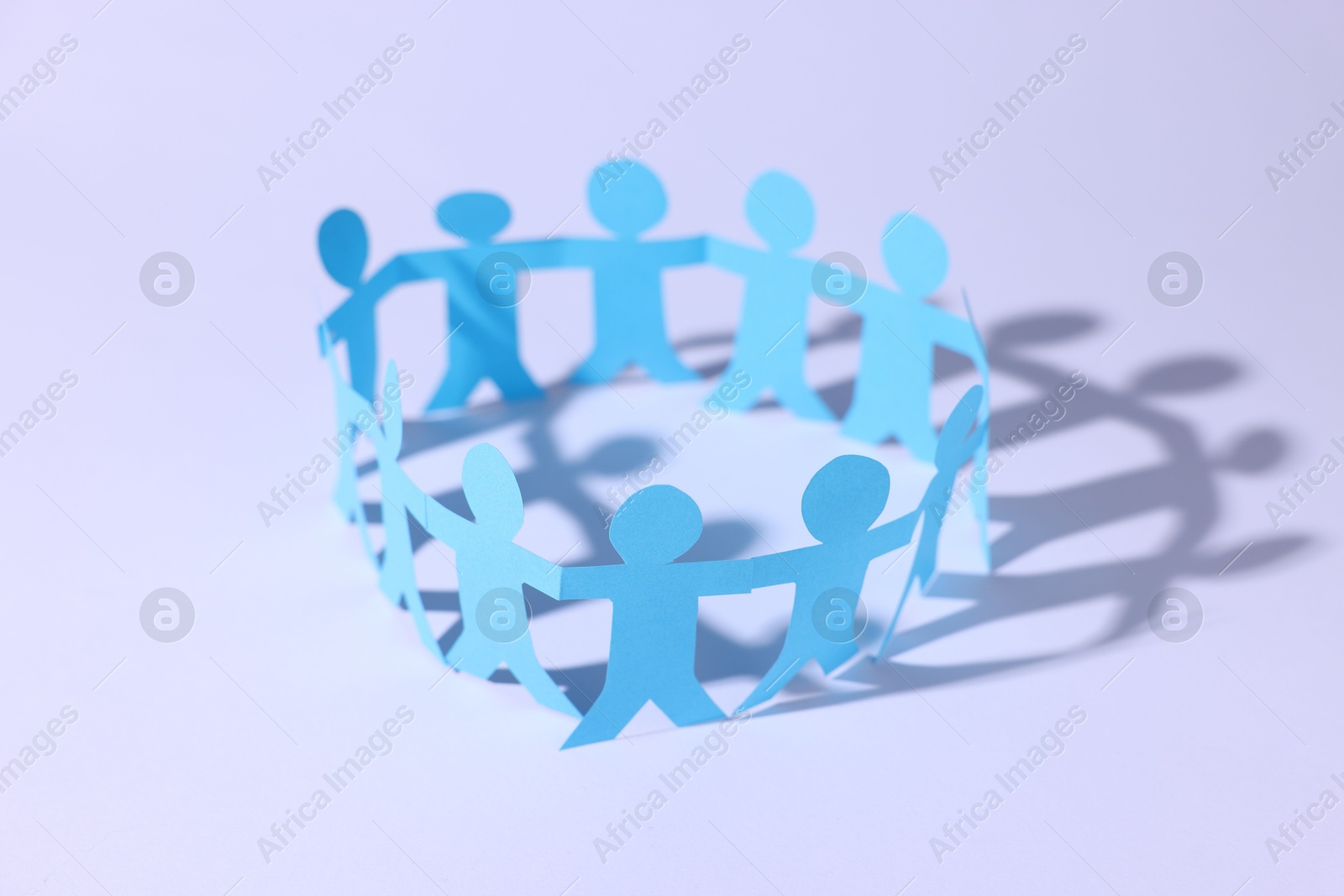 Paper figures of people holding hands on white background, closeup Photo of Paper figures of people holding hands on white background, closeup