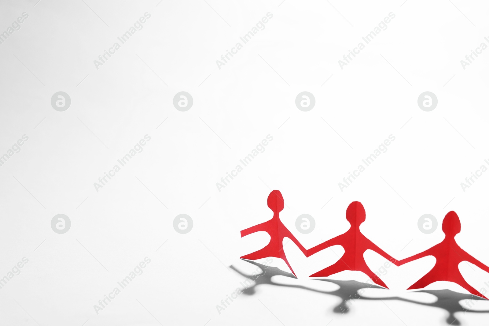 Paper figures of people holding hands on white background, space for text Photo of Paper figures of people holding hands on white background, space for text
