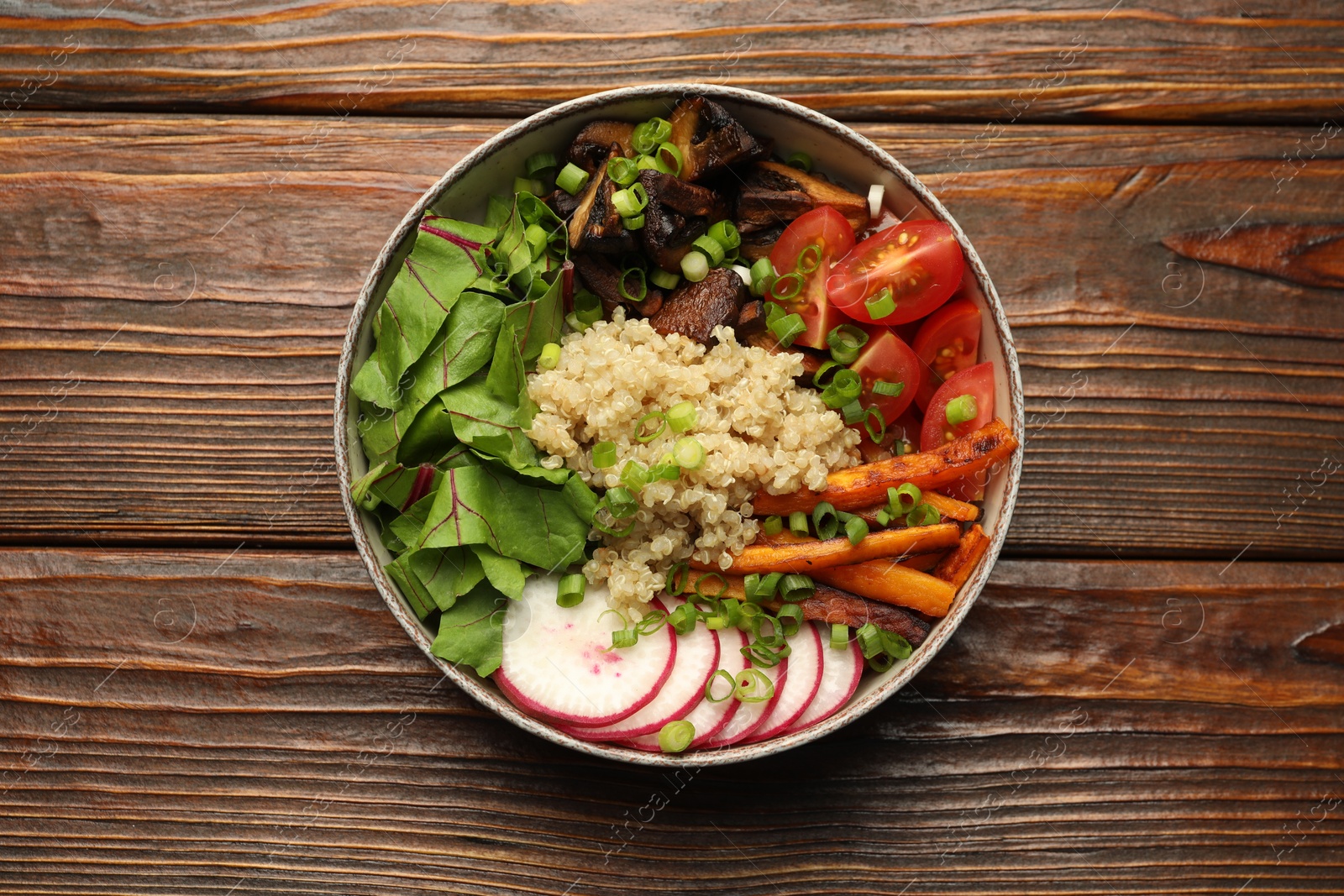 Healthy vegetarian food. Delicious Buddha bowl with quinoa, mushrooms and vegetables on wooden table, top view Photo of Healthy vegetarian food. Delicious Buddha bowl with quinoa, mushrooms and vegetables on wooden table, top view