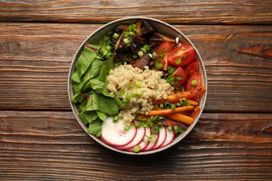 Photo of Healthy vegetarian food. Delicious Buddha bowl with quinoa, mushrooms and vegetables on wooden table, top view