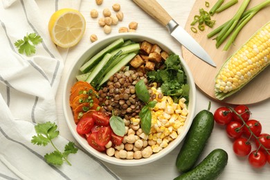 Photo of Healthy vegetarian food. Delicious Buddha bowl and ingredients on light wooden table, flat lay