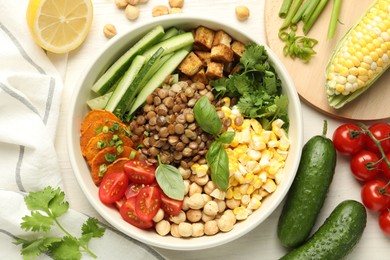 Photo of Healthy vegetarian food. Delicious Buddha bowl and ingredients on light wooden table, flat lay