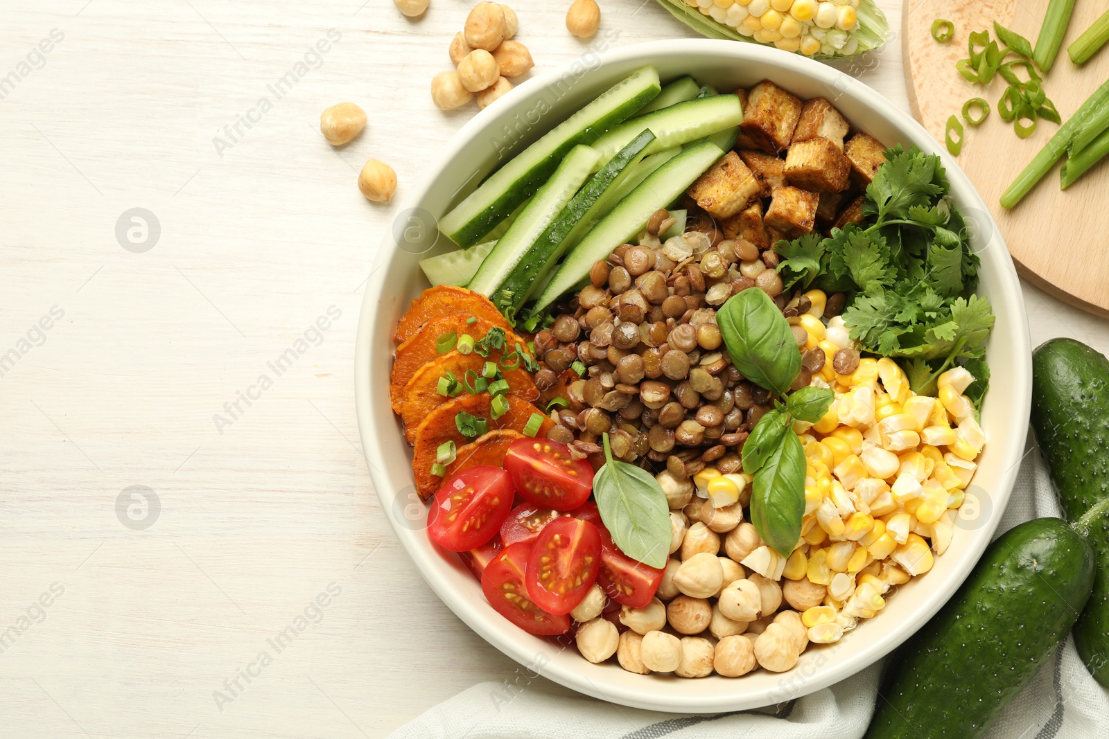 Healthy vegetarian food. Delicious Buddha bowl and ingredients on light wooden table, flat lay. Space for text Photo of Healthy vegetarian food. Delicious Buddha bowl and ingredients on light wooden table, flat lay. Space for text