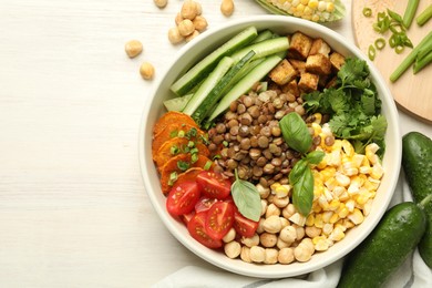 Photo of Healthy vegetarian food. Delicious Buddha bowl and ingredients on light wooden table, flat lay. Space for text