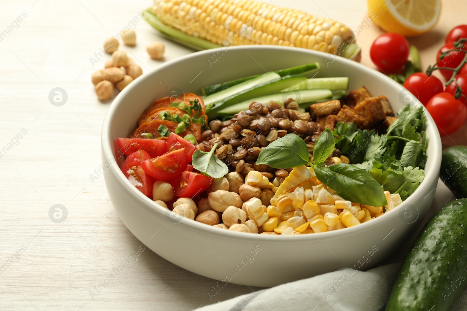 Healthy vegetarian food. Delicious Buddha bowl and ingredients on light wooden table, closeup. Space for text Photo of Healthy vegetarian food. Delicious Buddha bowl and ingredients on light wooden table, closeup. Space for text