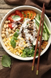 Photo of Healthy vegetarian food. Delicious Buddha bowl served on wooden table, top view