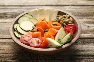 Photo of Healthy vegetarian food. Delicious Buddha bowl with lentils, tofu and vegetables on wooden table, closeup