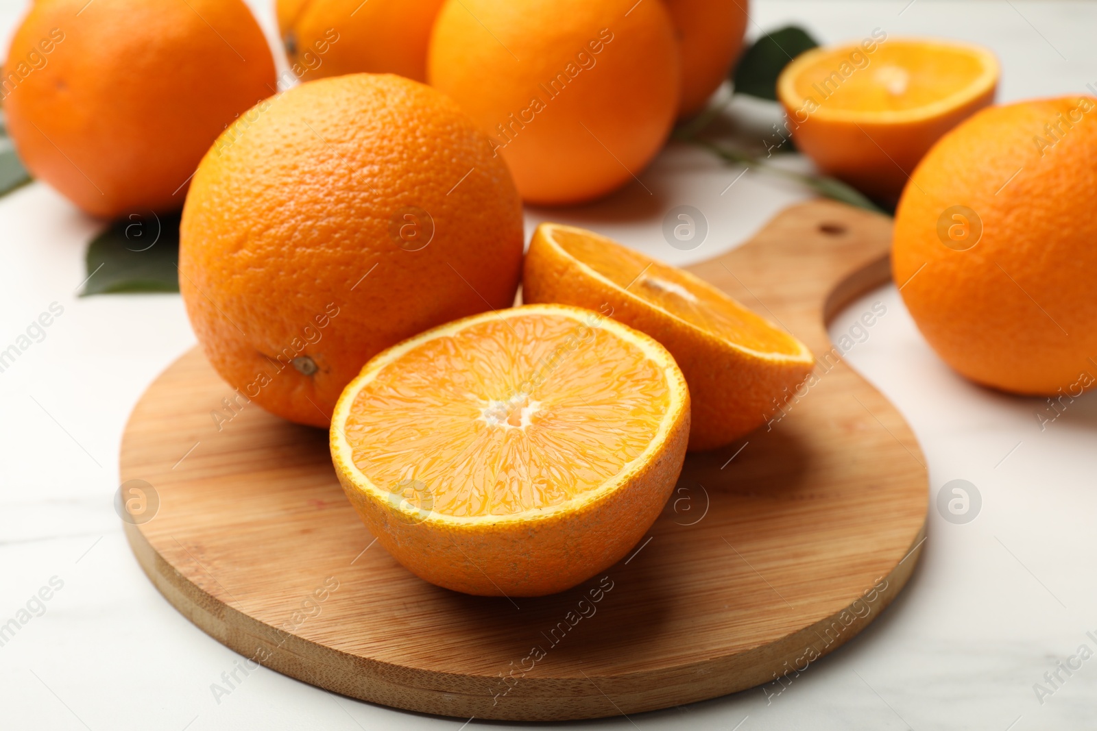 Whole and cut oranges on white table, closeup Photo of Whole and cut oranges on white table, closeup