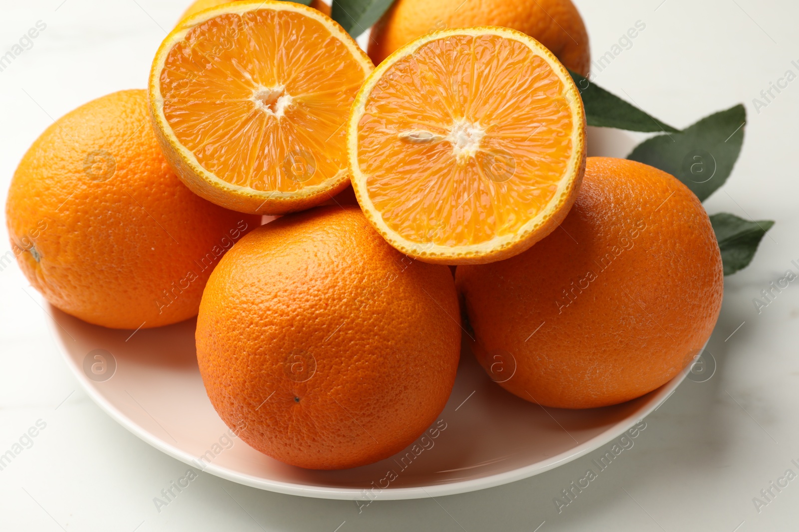 Whole and cut oranges on white table, closeup Photo of Whole and cut oranges on white table, closeup
