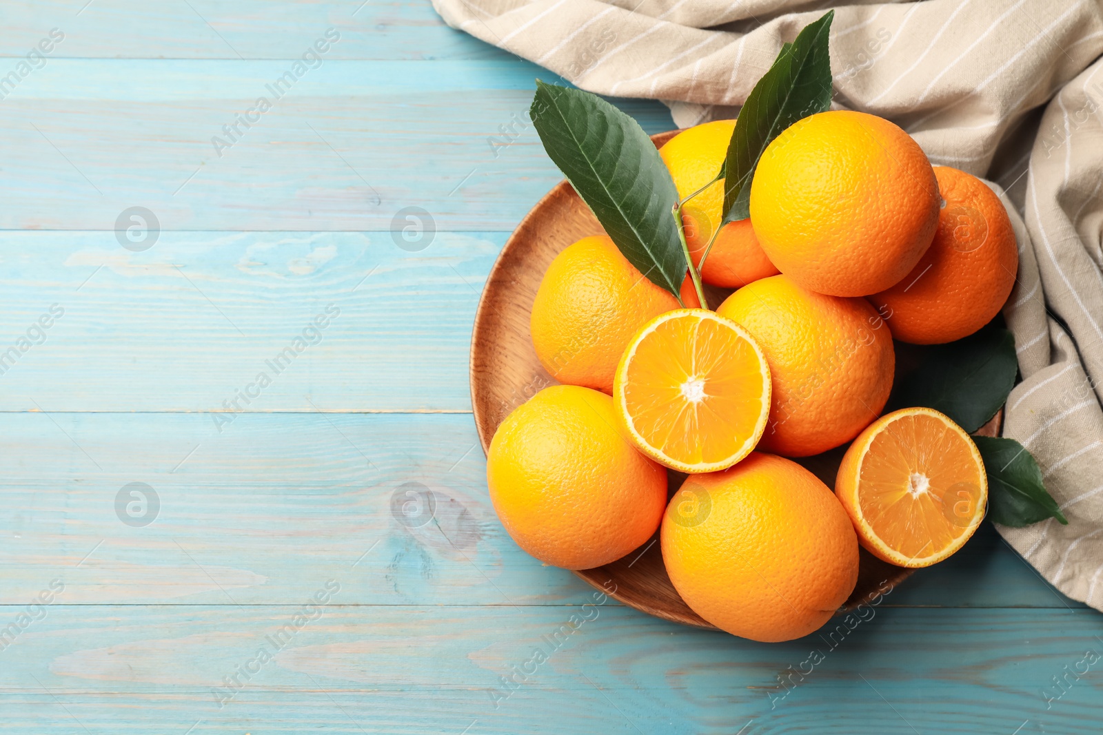 Fresh oranges and leaves on light blue wooden table, top view. Space for text Photo of Fresh oranges and leaves on light blue wooden table, top view. Space for text