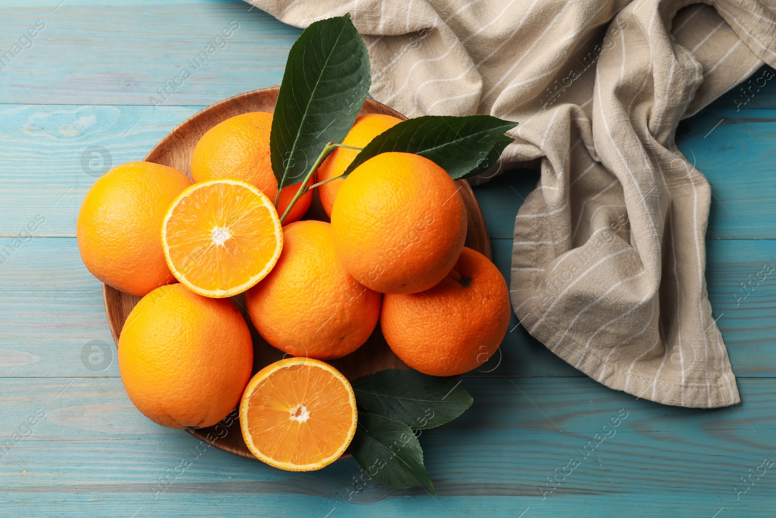 Fresh oranges and leaves on light blue wooden table, top view Photo of Fresh oranges and leaves on light blue wooden table, top view