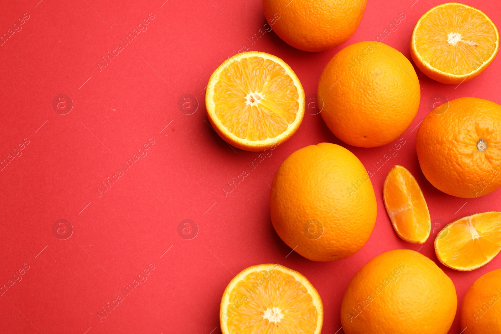 Fresh ripe oranges on red background, flat lay. Space for text Photo of Fresh ripe oranges on red background, flat lay. Space for text