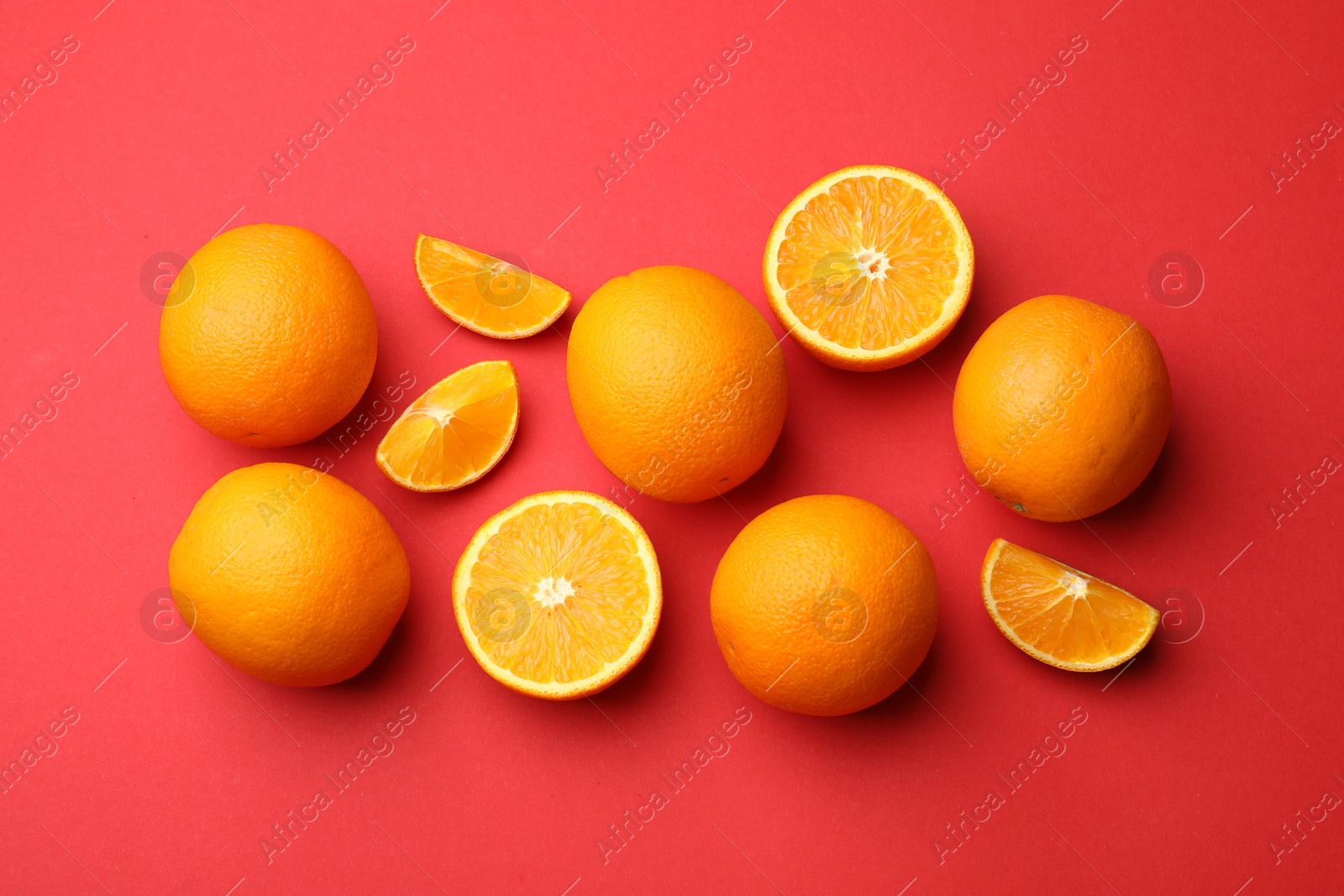 Fresh ripe oranges on red background, flat lay Photo of Fresh ripe oranges on red background, flat lay