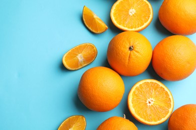 Photo of Fresh ripe oranges on light blue background, flat lay. Space for text