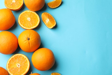 Photo of Fresh ripe oranges on light blue background, flat lay. Space for text