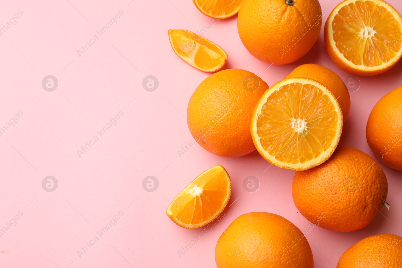 Fresh ripe oranges on pink background, flat lay. Space for text Photo of Fresh ripe oranges on pink background, flat lay. Space for text