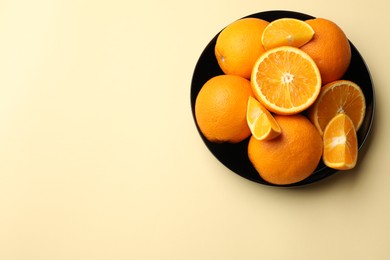 Photo of Fresh ripe oranges on beige background, top view. Space for text