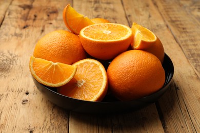 Photo of Fresh ripe oranges on wooden table, closeup