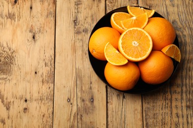 Photo of Fresh ripe oranges on wooden table, top view. Space for text