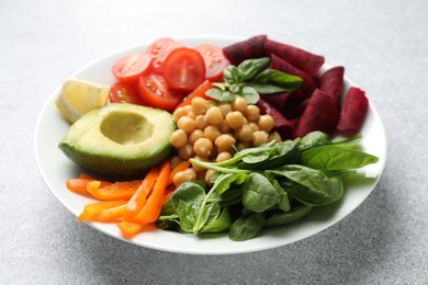Photo of Different healthy vegetarian food on light grey table, closeup