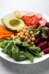 Photo of Different healthy vegetarian food on light grey table, closeup