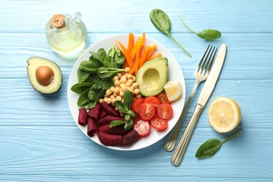Photo of Different healthy vegetarian food and cutlery on light blue wooden table, flat lay